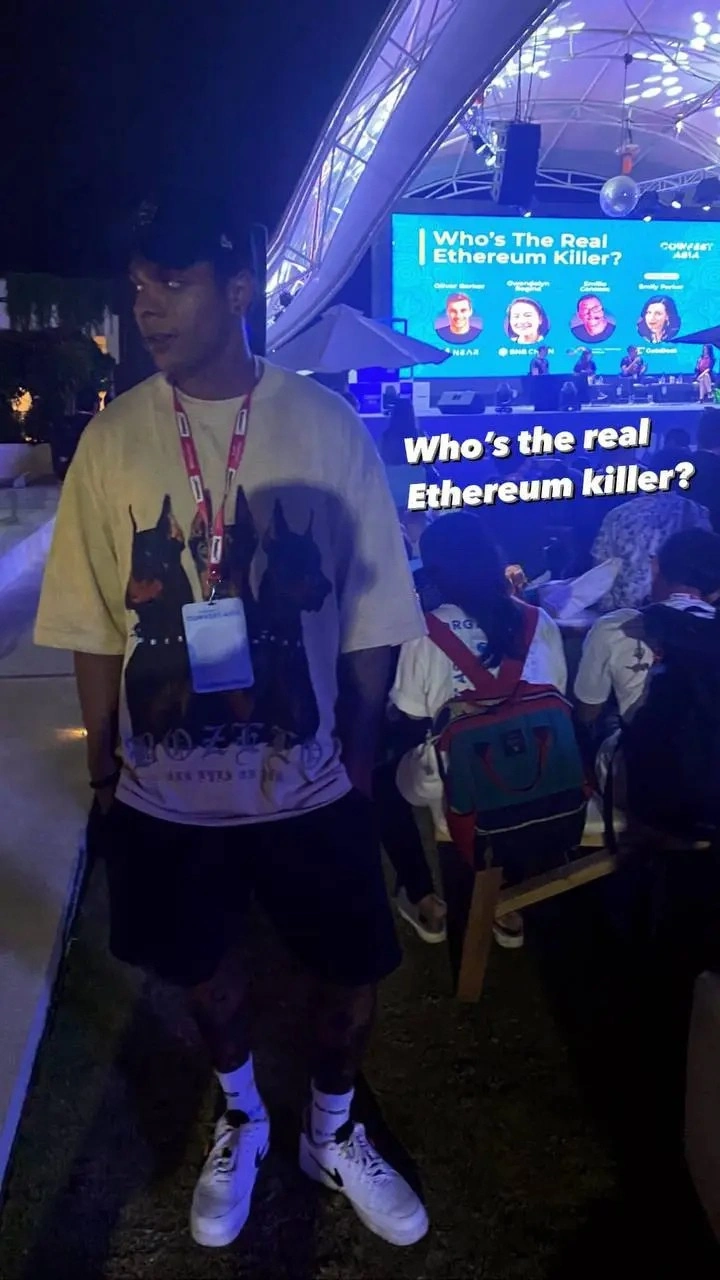 Contact 0xGravity - Image of a person at an event, with a presentation screen in the background